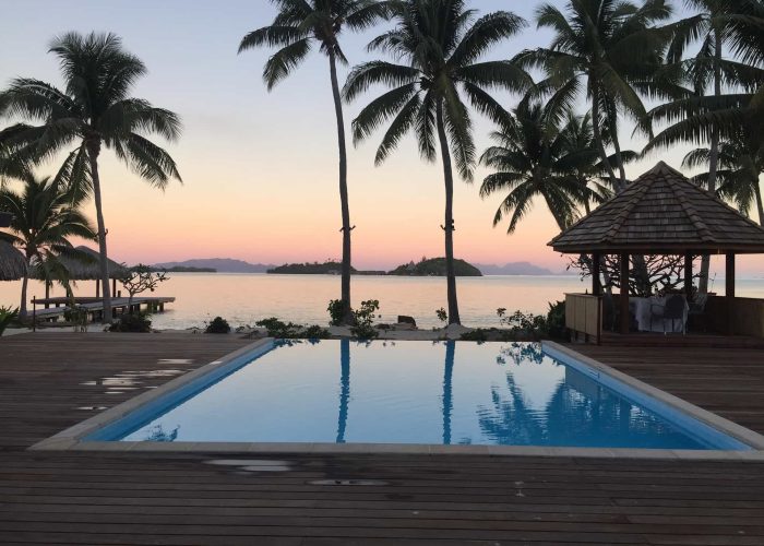 Vue piscine au coucher de soleil avec palmiers - Hôtel Royal Bora Bora 3***