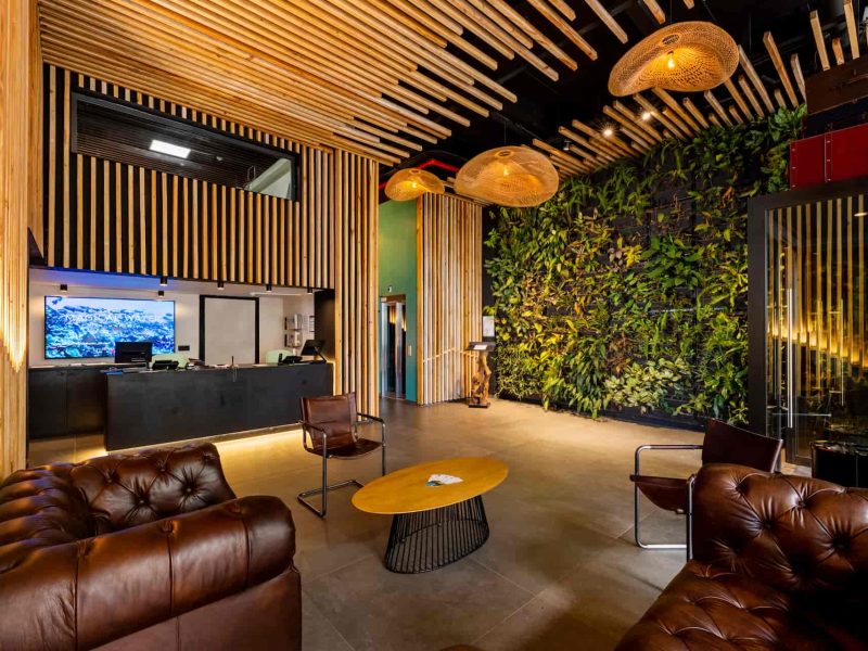 Vue intérieure du lobby, fauteuil en cuir et grand mur végétal - Hôtel Kon Tiki 3* à Papeete
