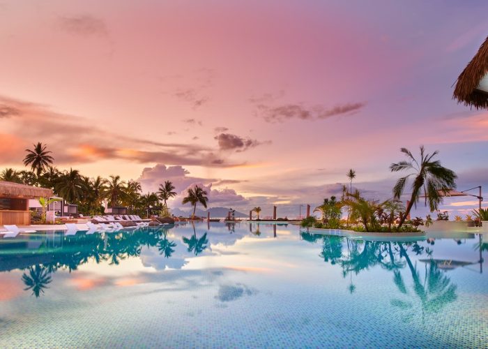 Vue panoramique piscine au coucher du soleil - Hôtel Hilton 5* à Tahiti