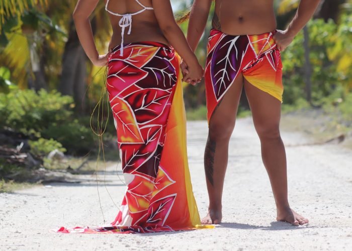 bas du corps d'un homme et une femme vêtus d'un paréo. Porté en jupe longue pour la femme et en short pour l'homme.