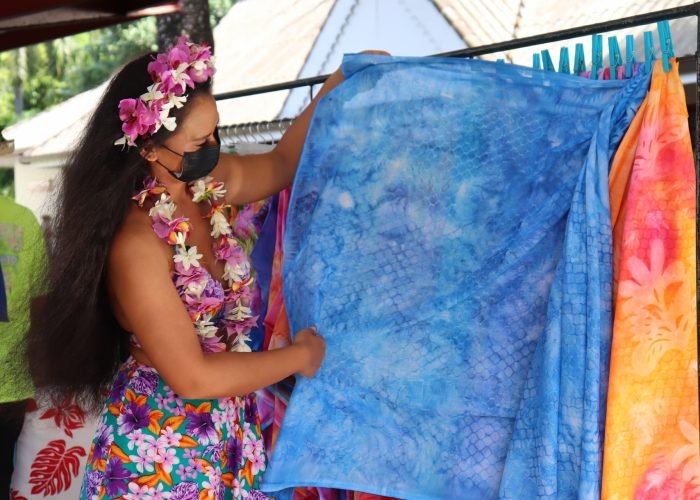 femme polynésienne exposant un paréo artisanal de couleur bleu